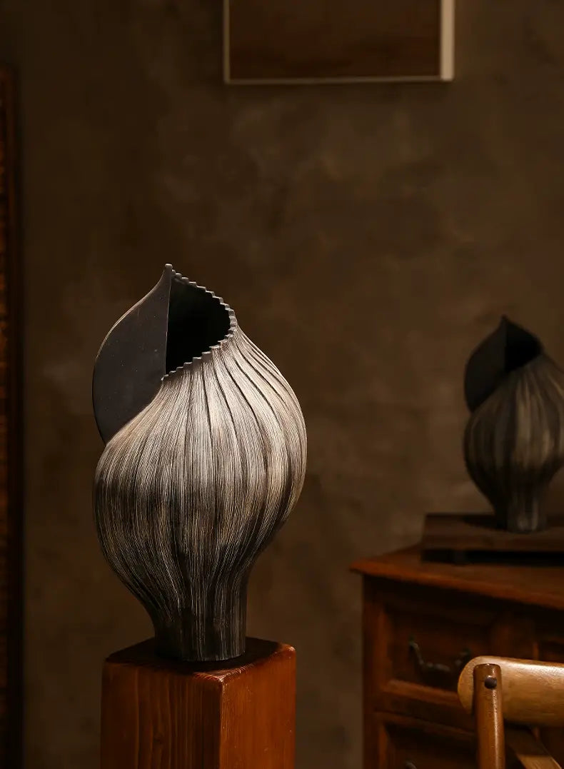 Black sculptural ceramic vase styled with dried branches for an organic botanical arrangement