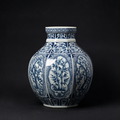 Blue and white porcelain vase with intricate botanical panel motifs