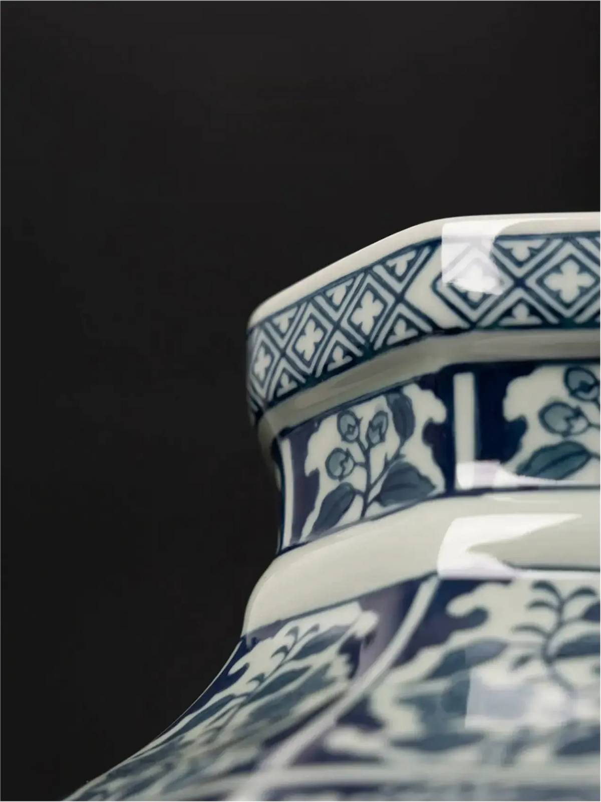 Blue and white porcelain vase with framed botanical scenes and geometric motifs