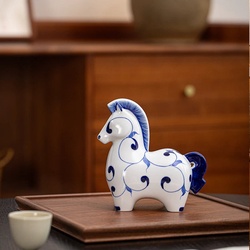 Minimalist oriental ceramic horse sculpture, bright white body decorated with deep blue hand-painted patterns, desktop home decor