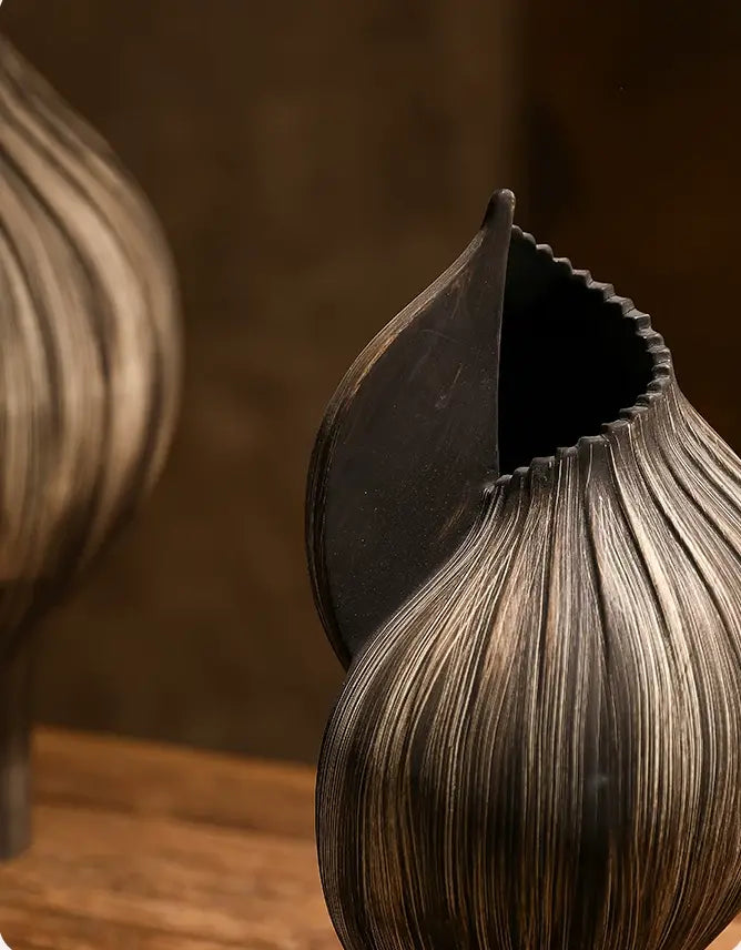 Handmade organic ceramic vase featuring a ribbed surface, flowing curves, and an irregular opening