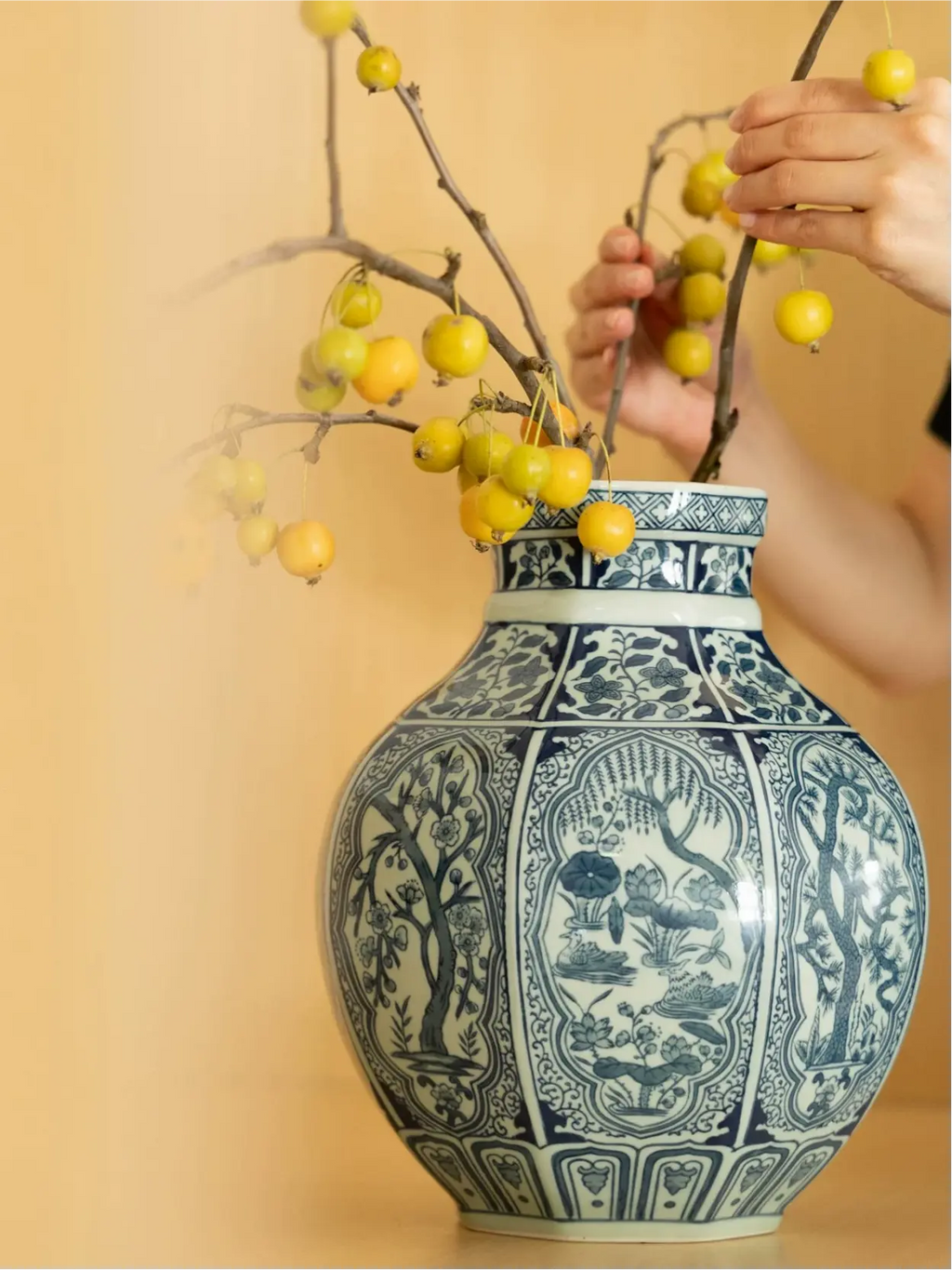 Oriental porcelain vase featuring blue botanical scenes and geometric borders