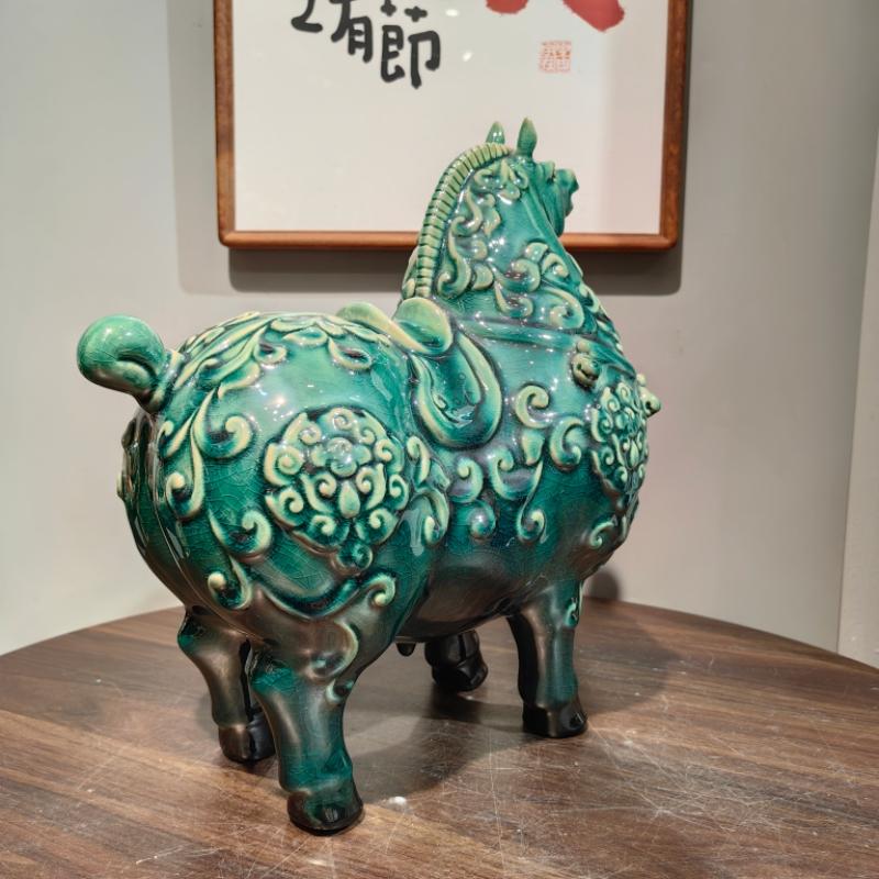 Close-up of translucent craquelure glaze and embossed botanical carvings on Tang horse
