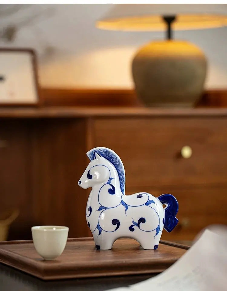 Minimalist oriental ceramic horse sculpture, bright white body decorated with deep blue hand-painted patterns, desktop home decor