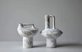 Wabi sabi ceramic handle vase on plain white background, product shot of rustic pottery decor