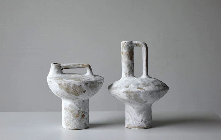 Wabi sabi ceramic handle vase on plain white background, product shot of rustic pottery decor